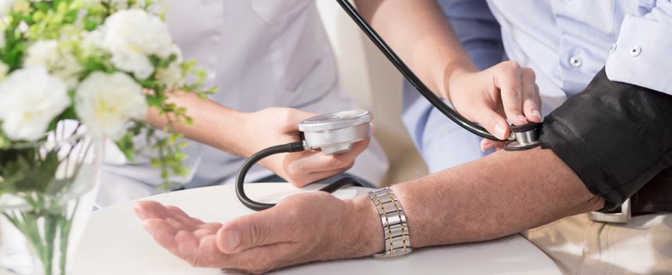 home health nurse taking blood pressure of senior at home