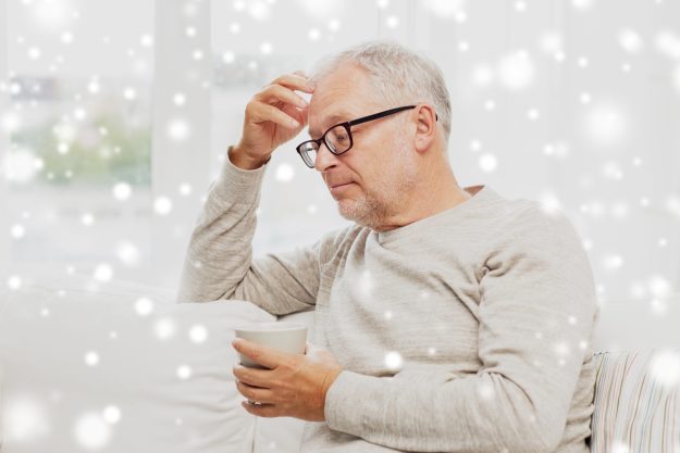 senior man with cup of tea at home elderly depression during the holiday season