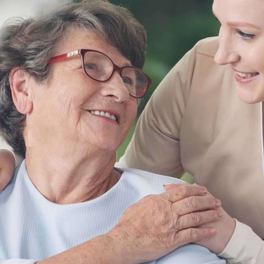 Caregiver comforting smiling senior woman finding a compassionate caregiver in New York