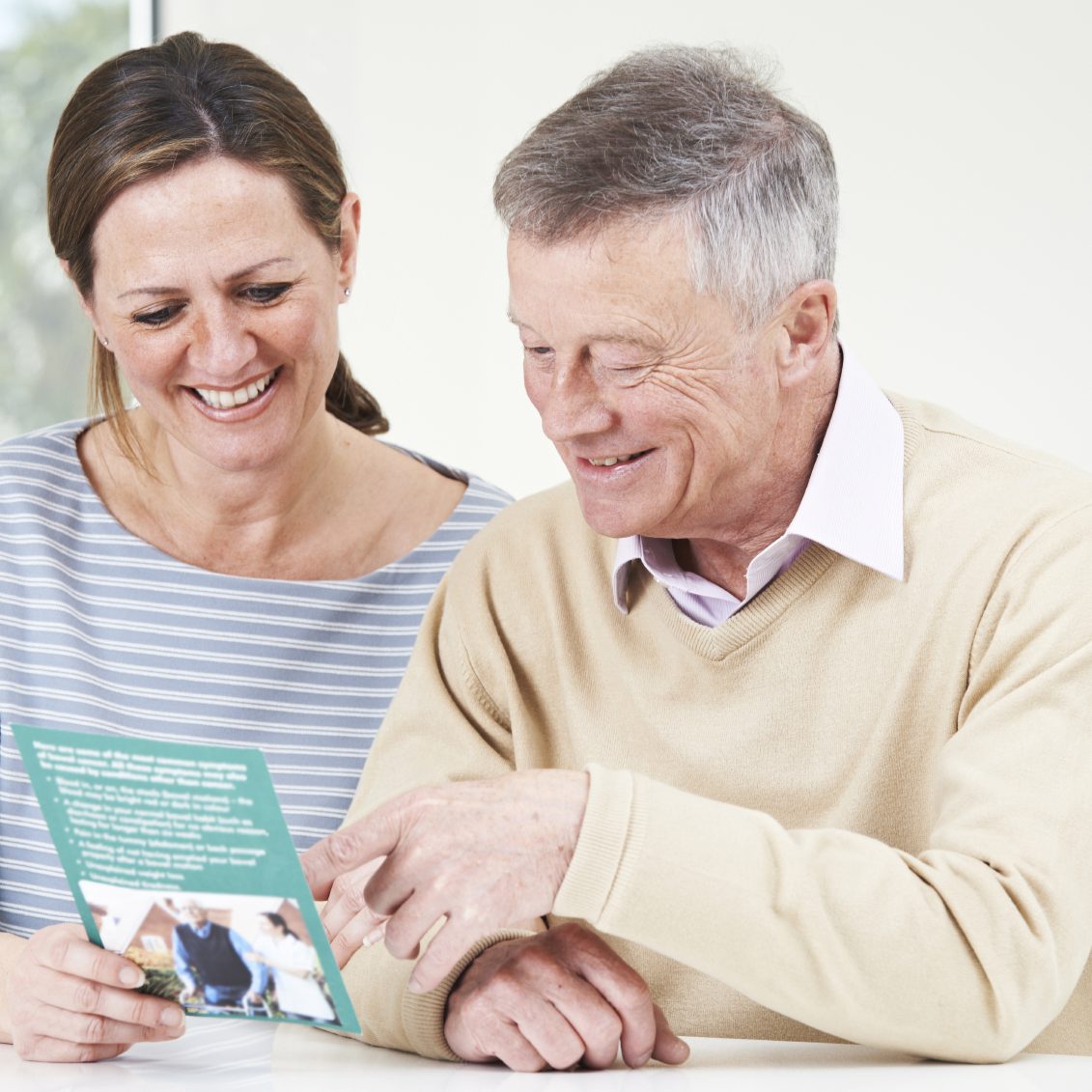 Senior Man With Adult Daughter Looking At Brochure For Retiremen eldercare services
