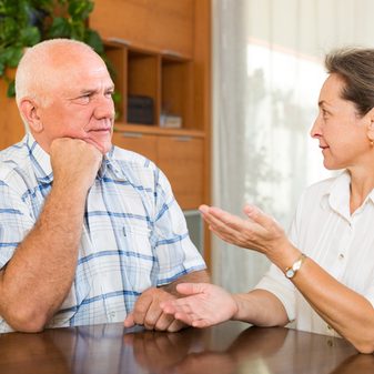 couple having serious talking in home interior eldercare planning and end-of-life discussion with a resistant senior