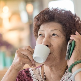 Happy Asian senior woman drinking tea at home. Happy Asian senior woman drinking tea at home.