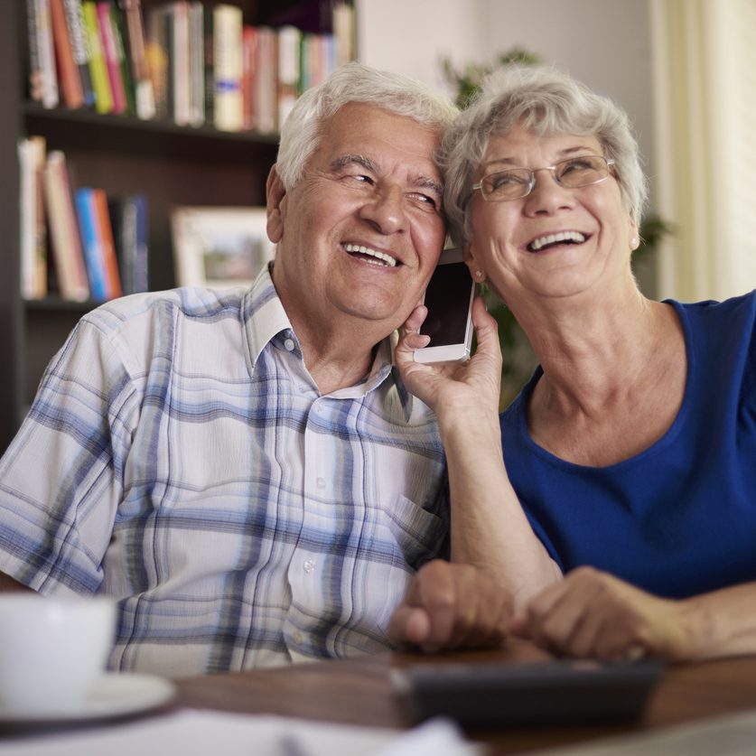 Grandparents talking on the phone at the table Grandparents talking on the phone at the table. Long-distance caregiving