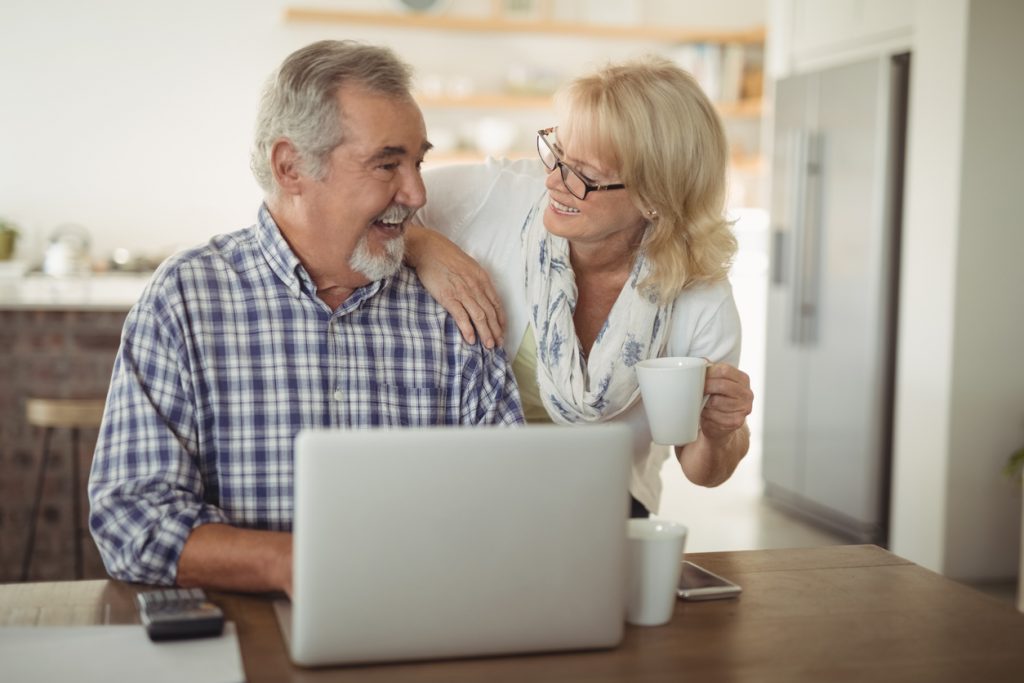 Senior couple using laptop to discuss eldercare planning at home