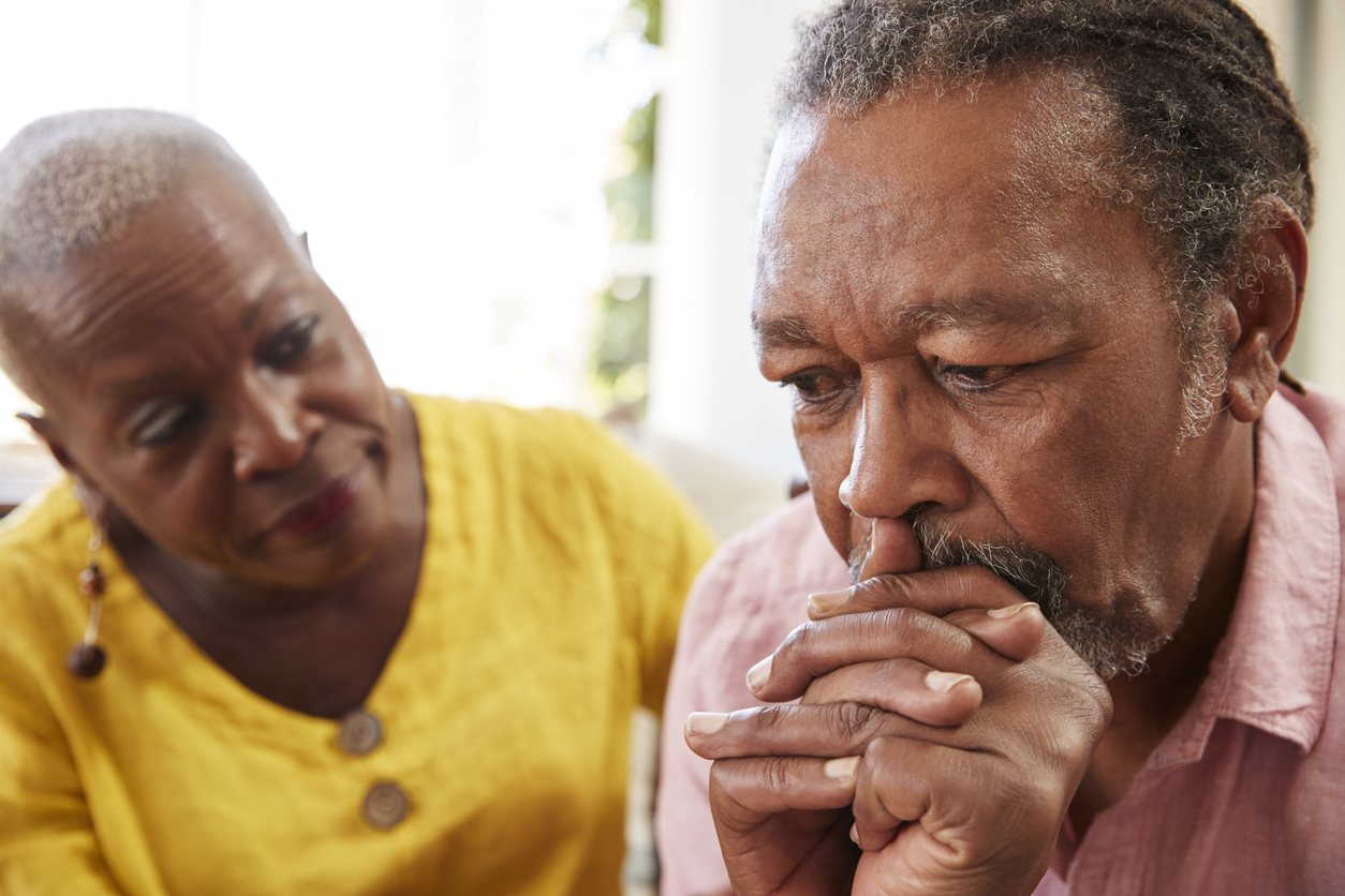 Senior Woman Comforting Man With Depression At Home elderly depression after holidays