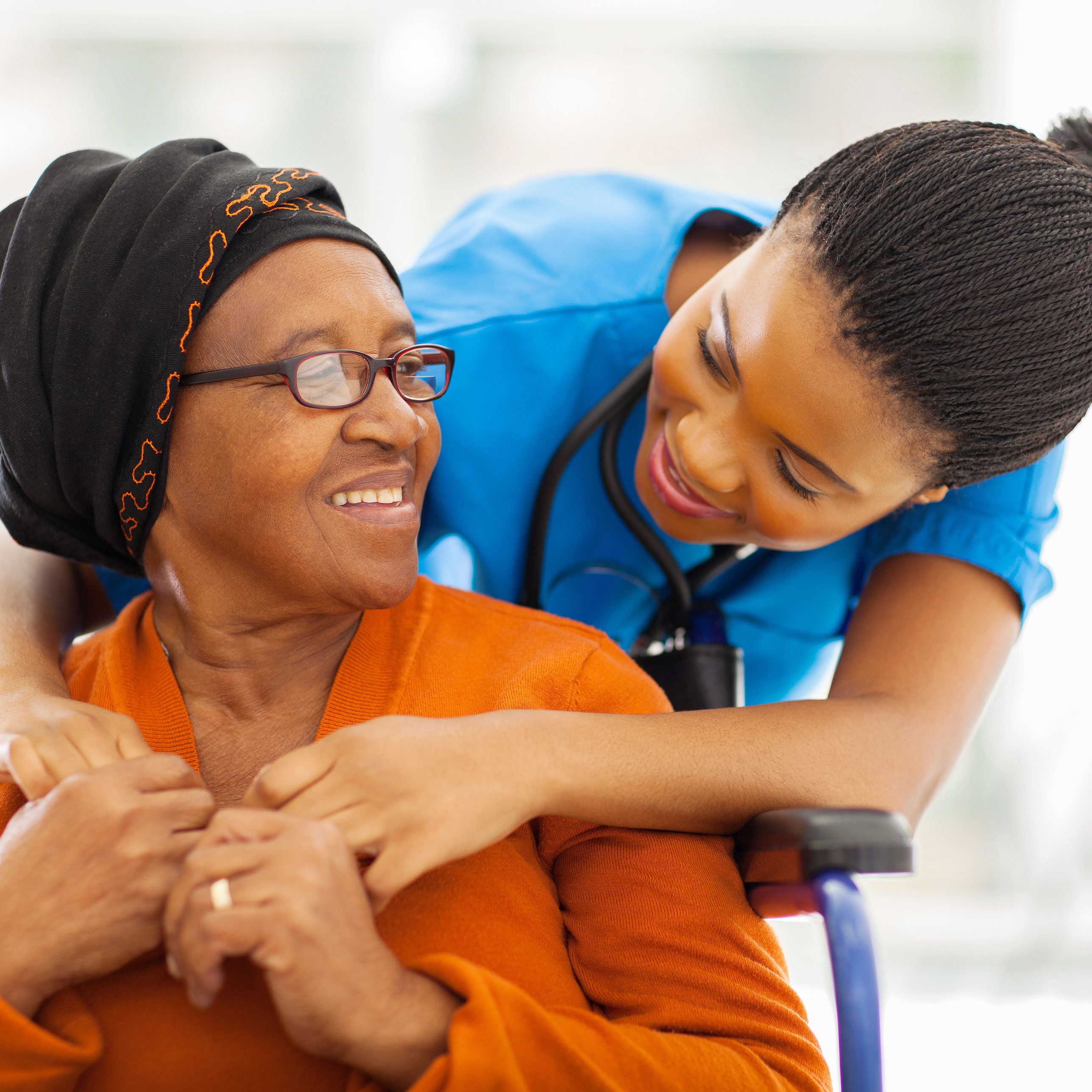Senior patient sharing a happy moment with her caregiver. Self-care tips for caregivers in Nassau County.