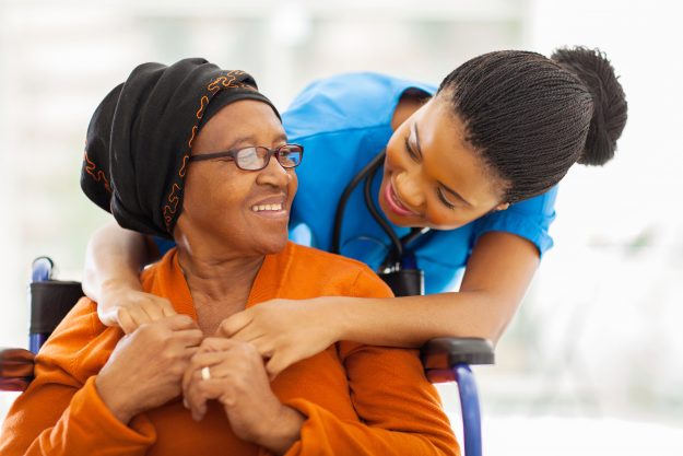 Senior patient sharing a happy moment with her caregiver. Self-care tips for caregivers in Nassau County.