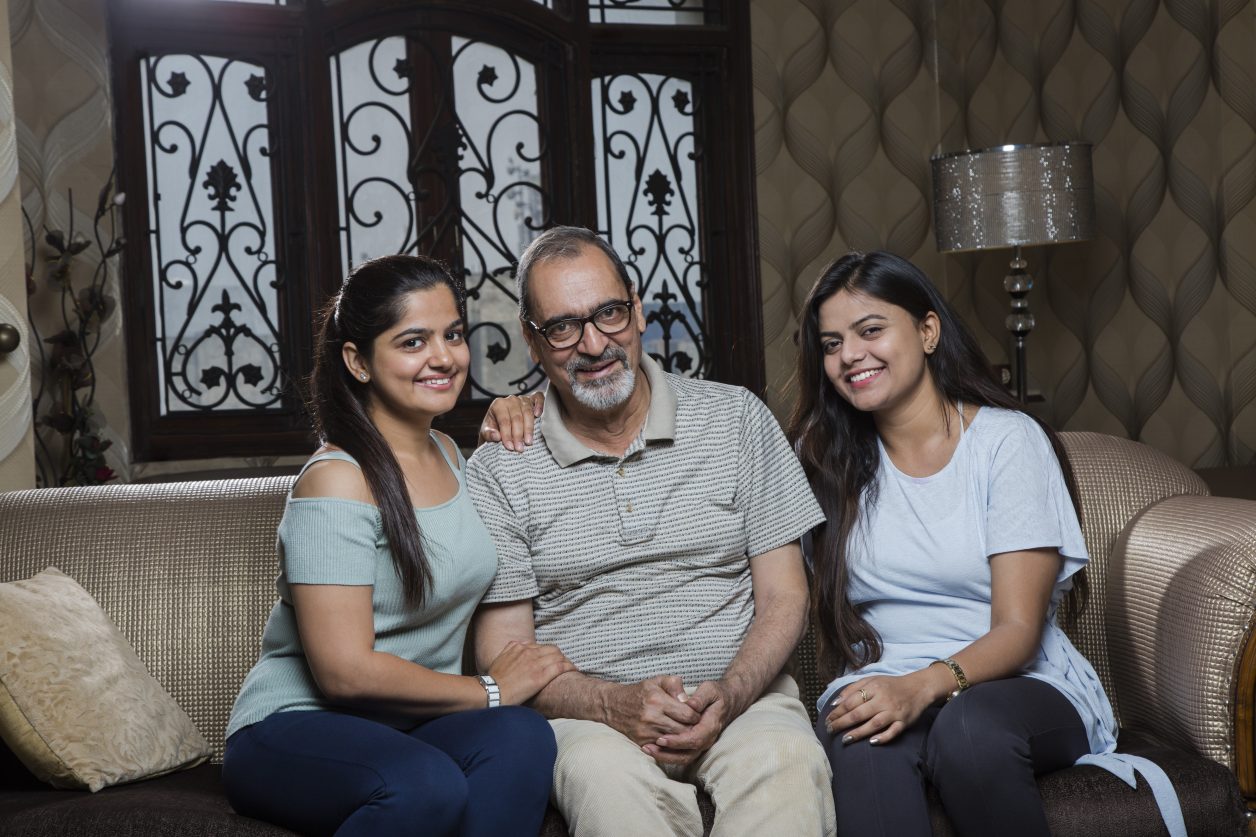 Happy Father And Two Daughters In Bayside, Queens Cooperative caregiving in Bayside. Two sisters sitting with their father in Bayside, Queens.