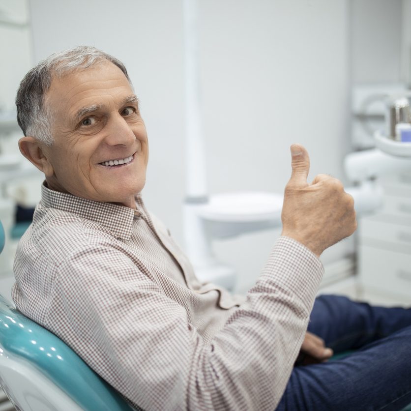 Happy senior man who is free of periodontal disease in New York City.