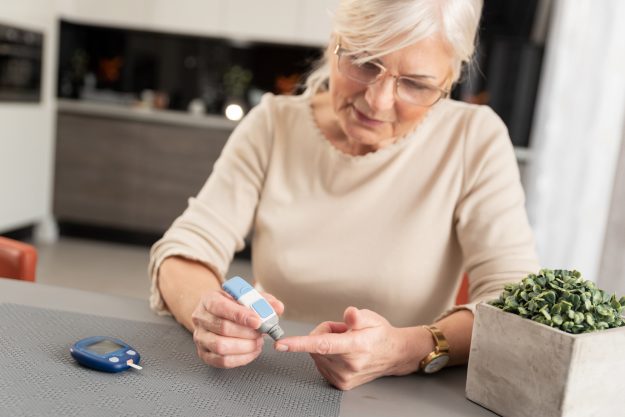 A senior woman with geriatric diabetes checking her blood glucose levels.
