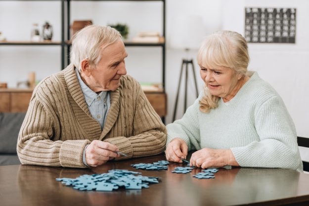 A senior couple playing with puzzles. Cerebral activities for seniors suffering from Parkinson's Disease.