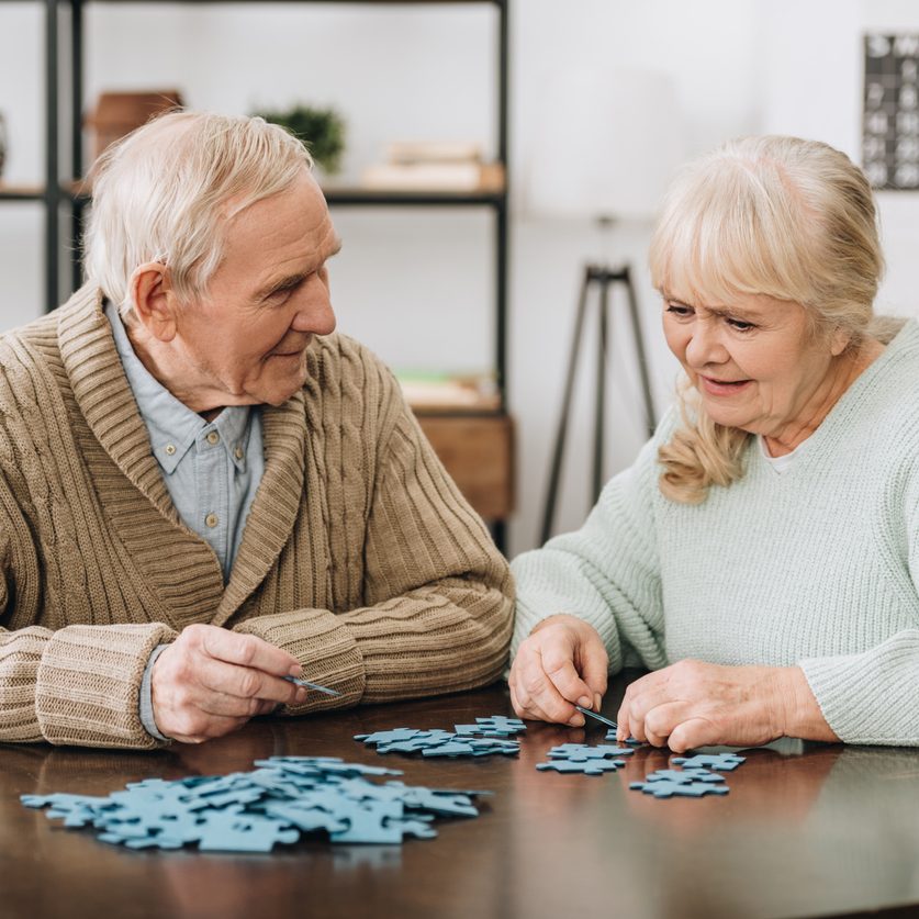 A senior couple playing with puzzles. Cerebral activities for seniors suffering from Parkinson's Disease.