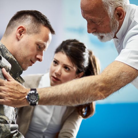 A doctor consoling a veteran with traumatic brain injuries in Todt Hill.