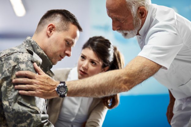 A doctor consoling a veteran with traumatic brain injuries in Todt Hill.