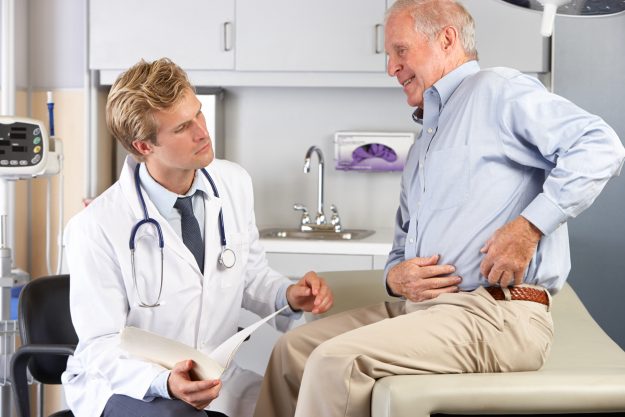 Doctor Examining Patient With Hip Pain in Brooklyn Heights A doctor discussing hip replacement alternatives with a male patient in Brooklyn Heights.
