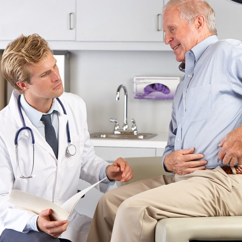 A doctor discussing hip replacement alternatives with a male patient in Brooklyn Heights.