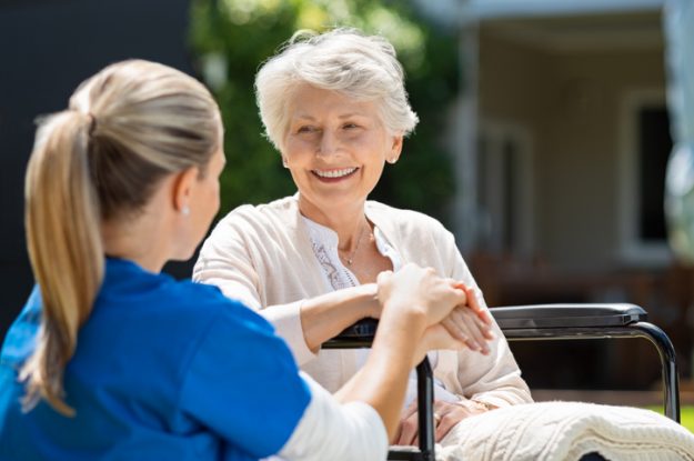 A nurse tending to female patient in Manhattan; happy senior patient who has found a solution to urinary incontinence.