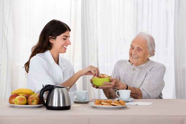 Elder Woman Offering Snack To Nurse unintentional weight in seniors
