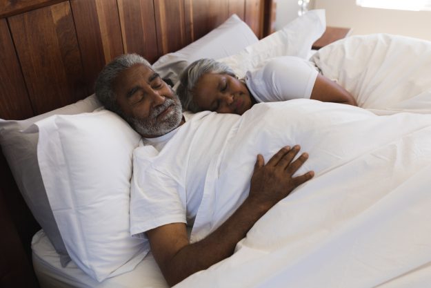 An elderly couple have a good night's rest due to healthy sleep habits.