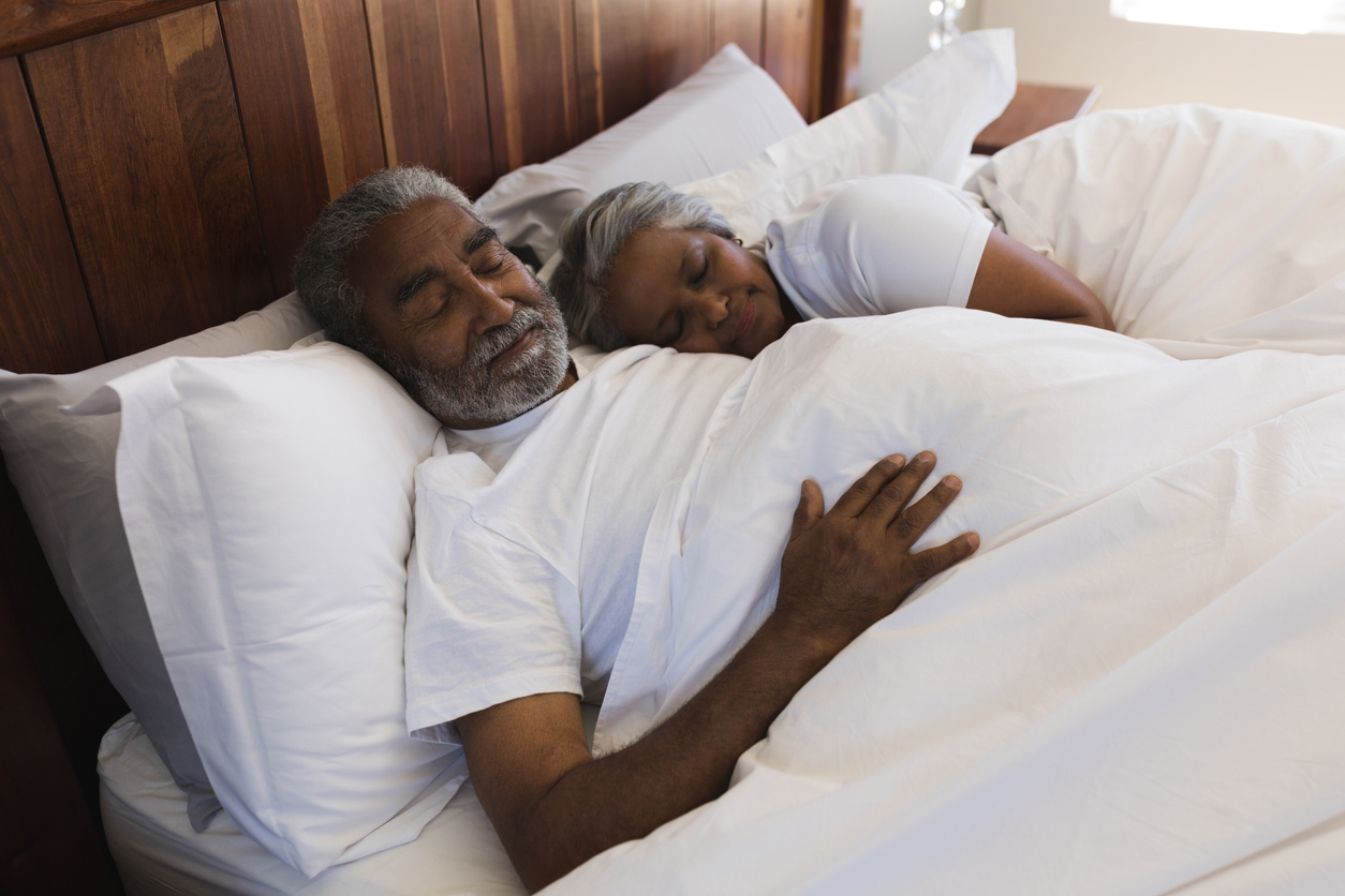An elderly couple have a good night's rest due to healthy sleep habits.
