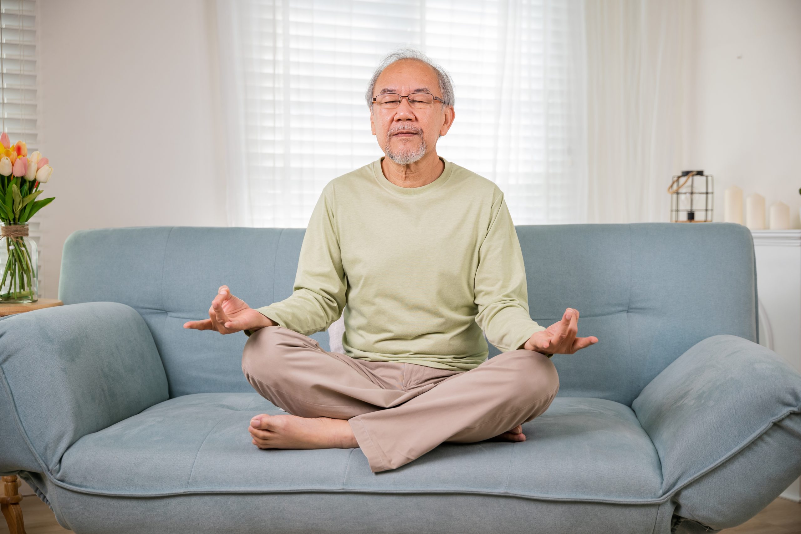 Asian old man practise yoga and meditation in lotus position and closed eyes Mindful practices for seniors and to relieve caregiver stress