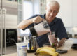 Elderly man makes a protein smoothie as part of a healthy diet to prevent hypertension.