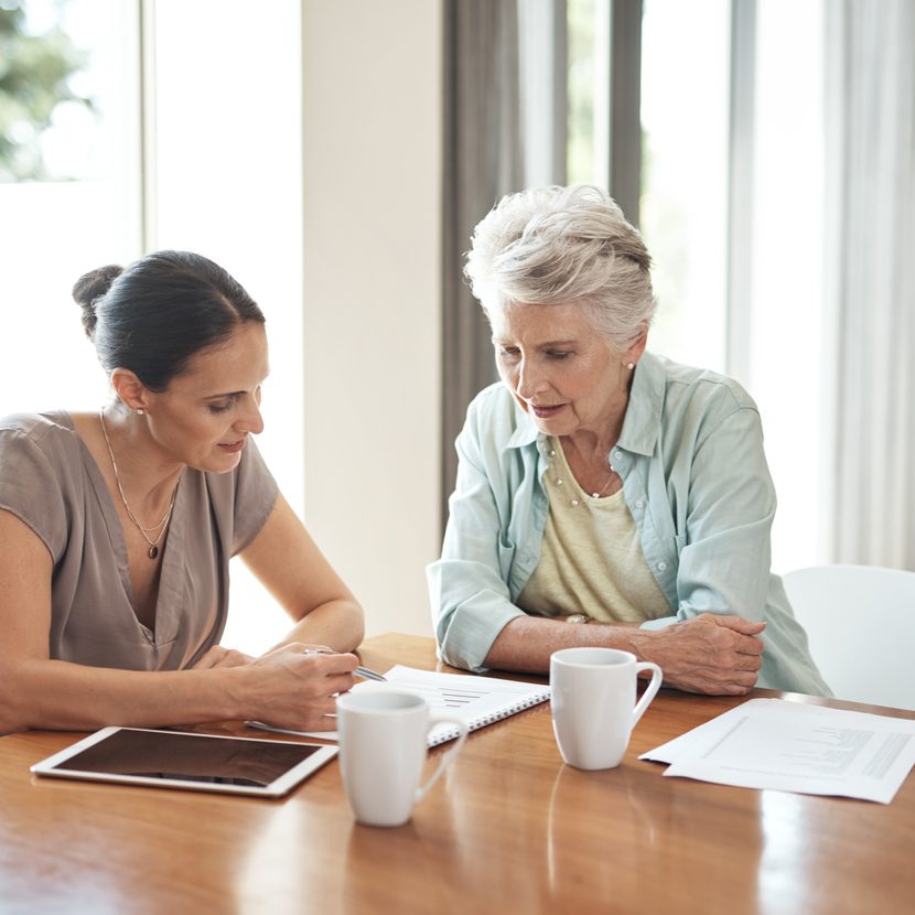A daughter helps her mother gather documents for eldercare planning.